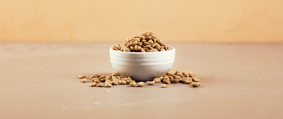 Green coffee beans in a white bowl