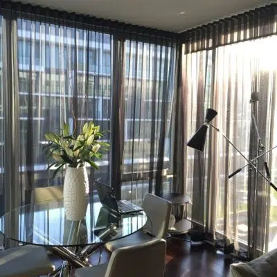 Dark sheer curtains filtering light in a dining area