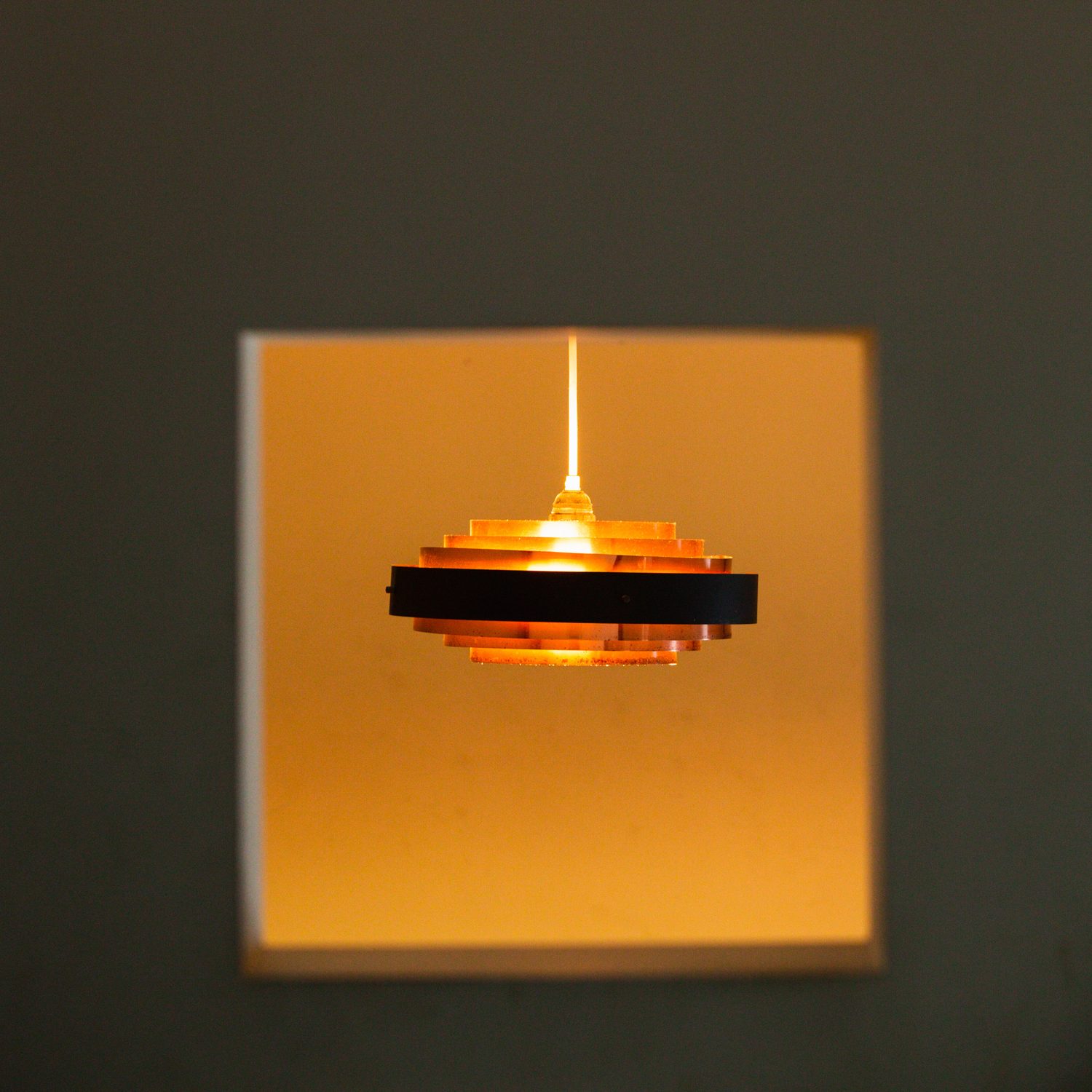 A copper pendant light hanging over the tables