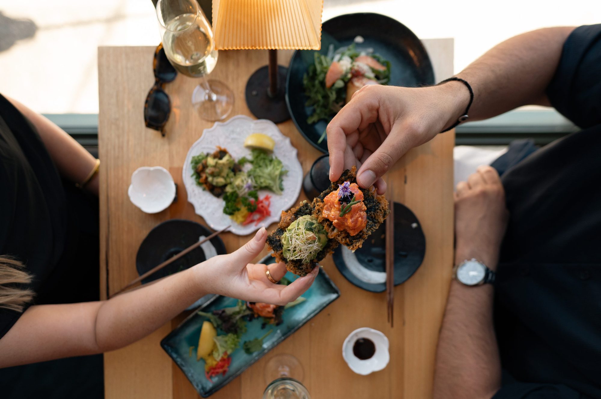 Dishes being shared across the middle of the table