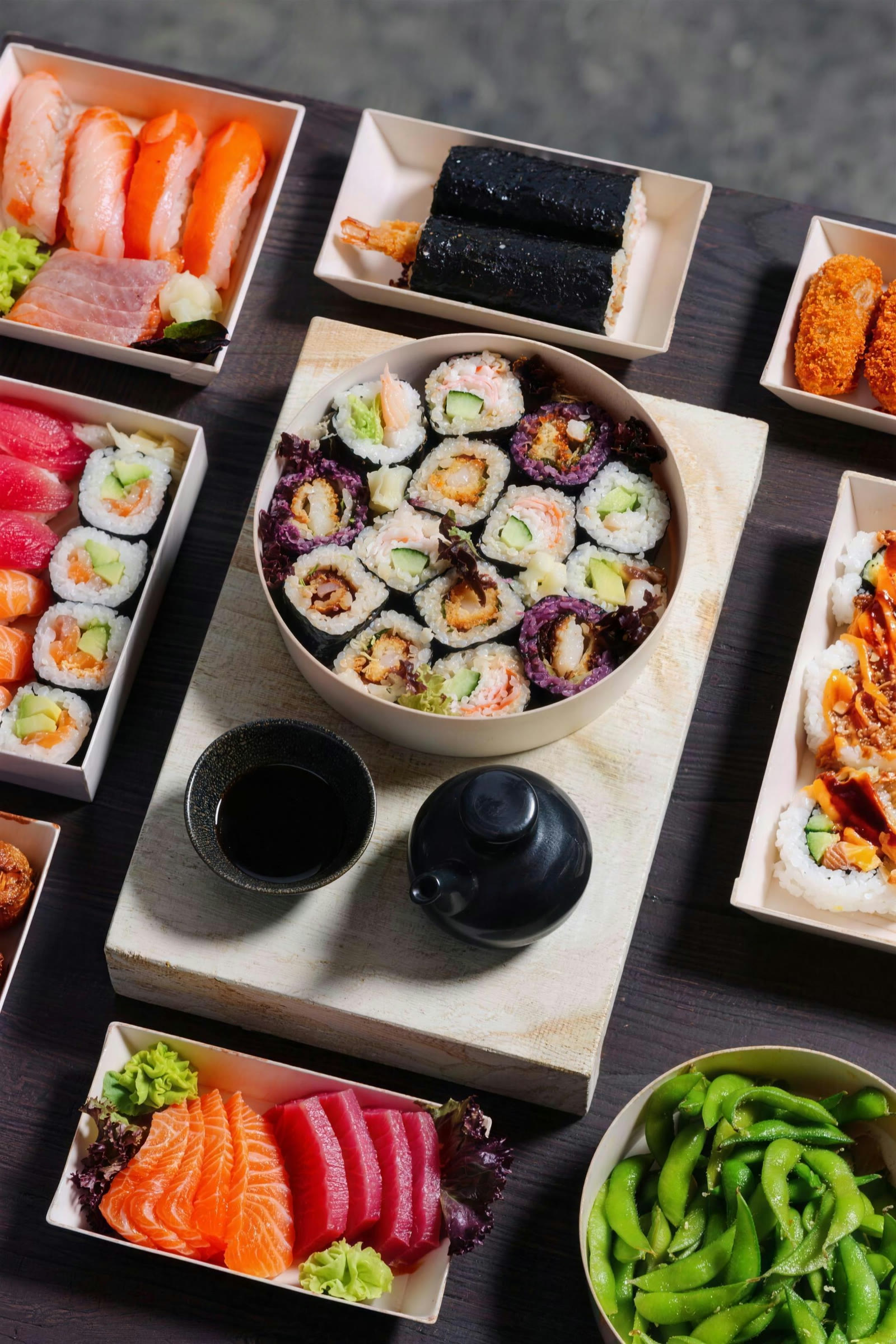 Overhead catering spread of nigiri, rolls, sashimi and edamame