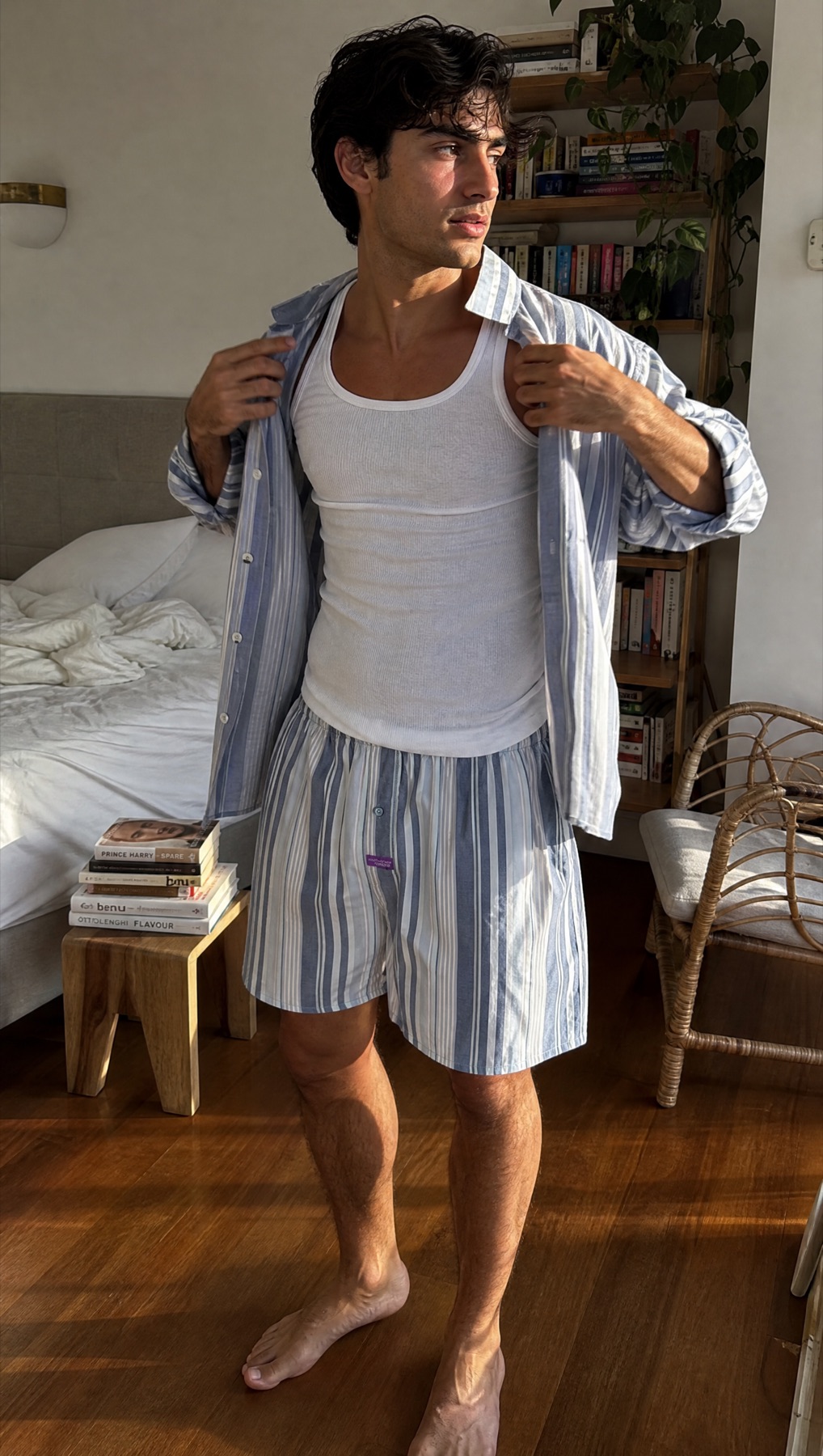 Model at home wearing a matching blue striped shirt and Mitch Dowd boxer shorts