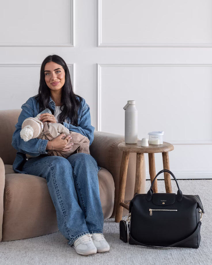 Parent and baby at home with feeding essentials