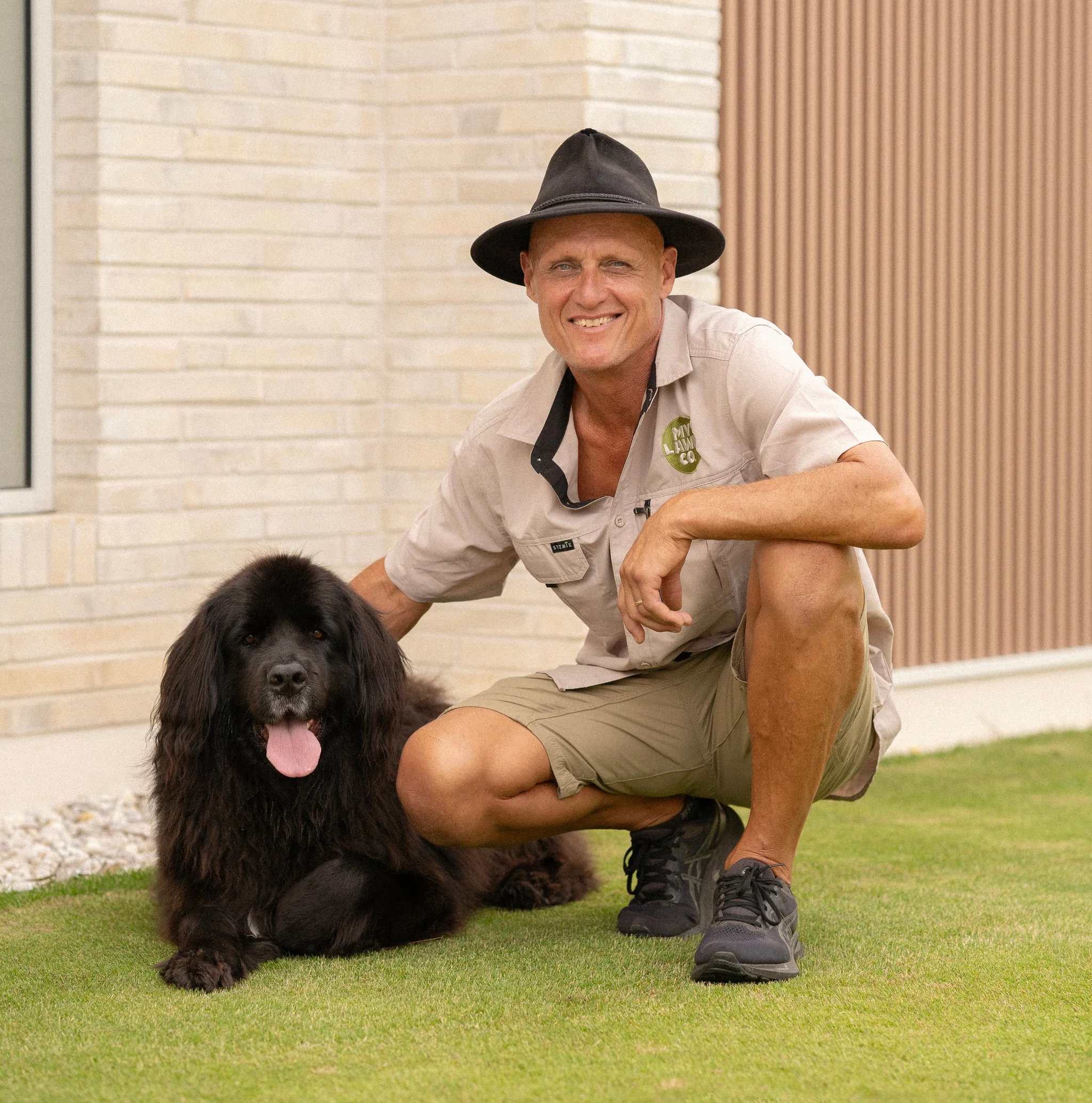Our founder Dave with a black dog on a healthy lawn