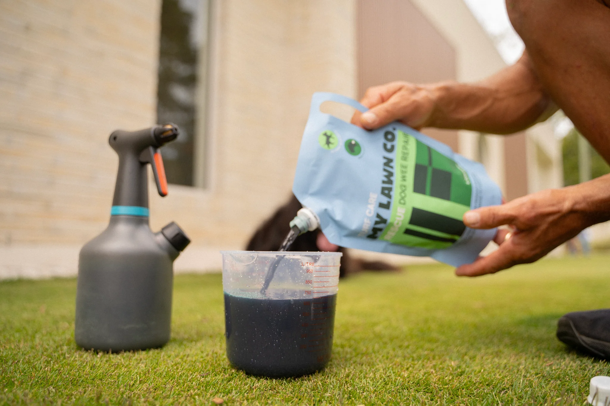 We measure RESCUE beside a pump sprayer before treating the lawn